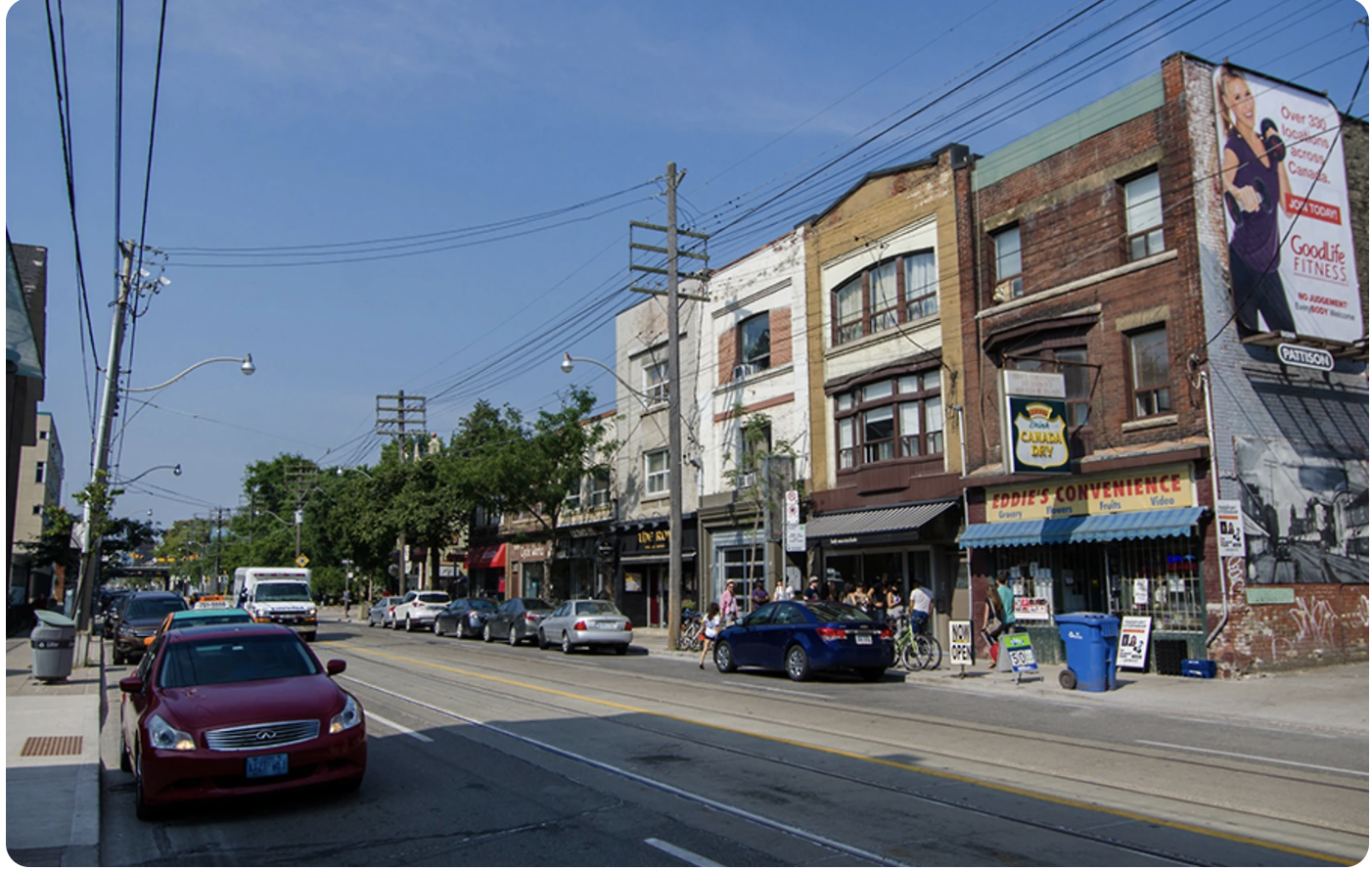 Leslieville streetscape with Eddie's Convenience, vintage brick buildings, and overhead wires on Dundas East